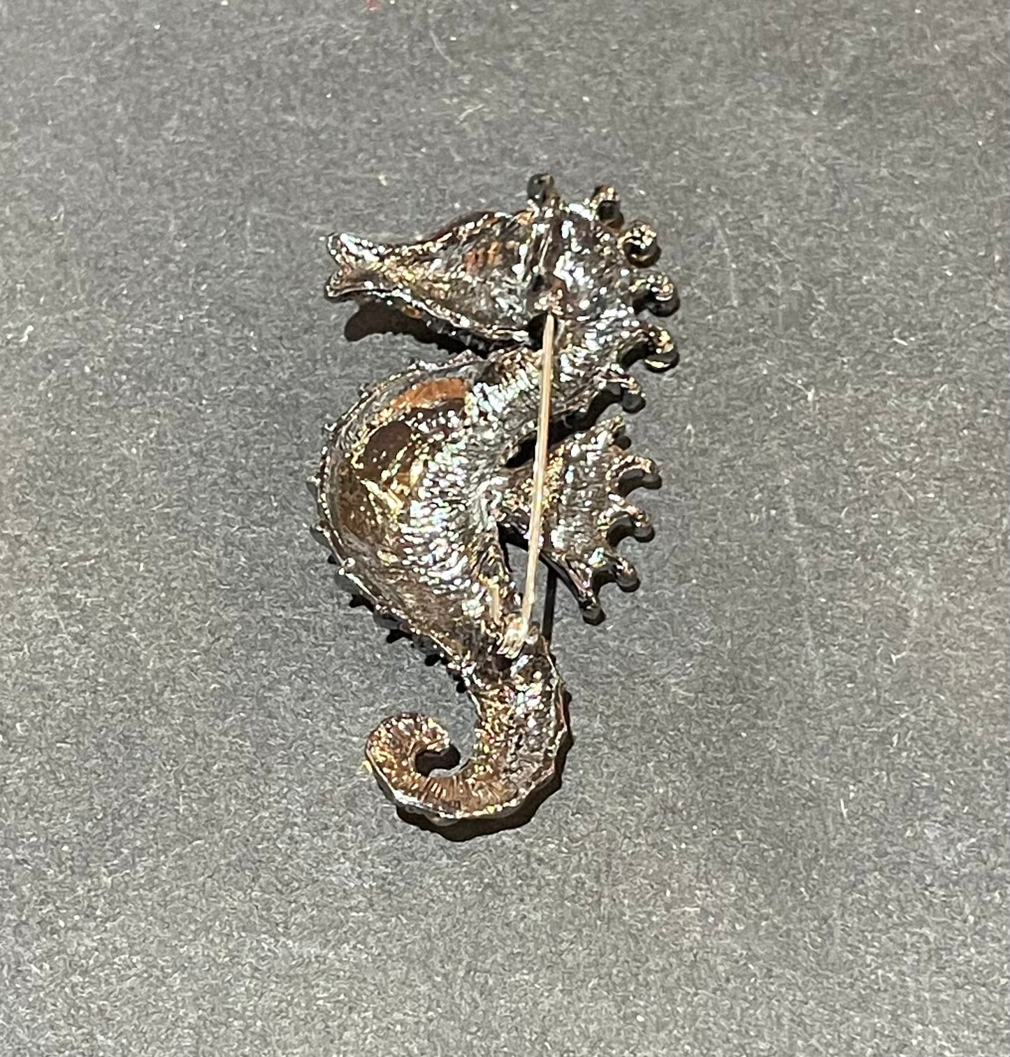 Spilla “cavalluccio marino” in acciaio placcato oro  18 kt e cristalli